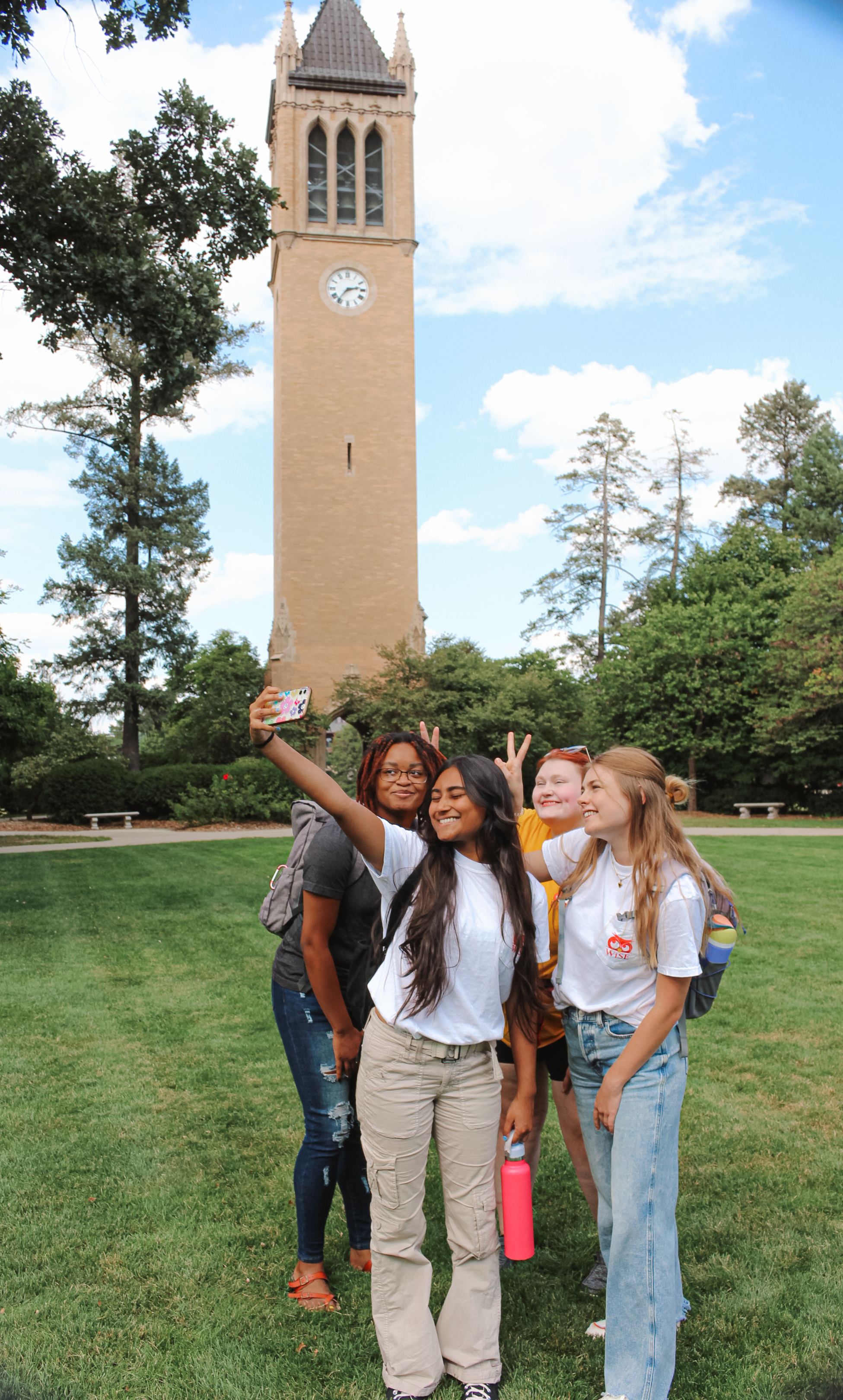Students taking a selfie in front of the Campanile.