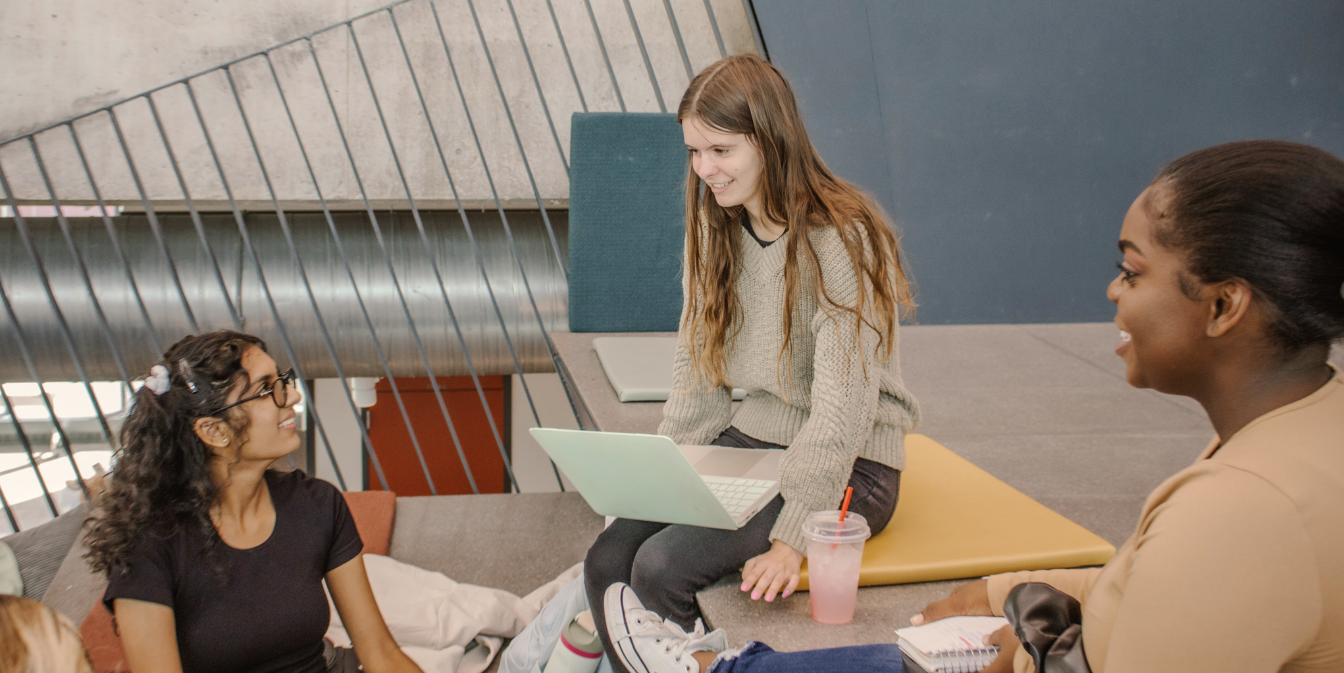 Three students studying on the steps of the SIC